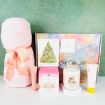 The A Loyal Society Pink Christmas Cheer Spa Gift set is an elegant gift for those who love all things pink. This gift set includes a pale pink knit throw blanket, a pink bath box in a Santa themed box, a Rosewater lotion, a rose lip balm, a Christmas Cheer scented candle and a Christmas tinsel tree card.