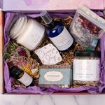 Photo Images of Self Care Everyday Gift Box By A Loyal Society Featuring Relaxation Candle, Floral Bath Soak, Sage Cleansing and Meditation Wand, Flower Water Spray, All Natural Soap Bar and Lavender and Rose Spa Salts. Self Care Kit